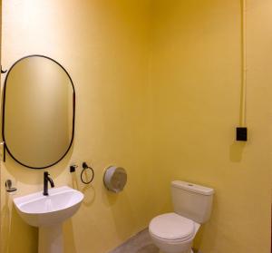 a bathroom with a sink and a toilet and a mirror at Casa Remolacha in Flores