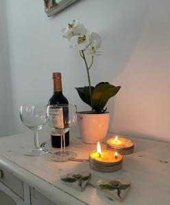 a table with candles and a bottle of wine and a flower at Inehouse in Concepción del Uruguay
