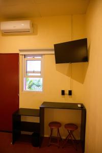 a room with a desk with two stools and a television at Casa Remolacha in Flores +22 photos