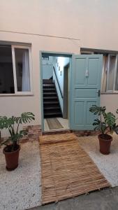 a house with a blue door and a staircase at Casa Vila Mar Guesthouse in Guaratuba