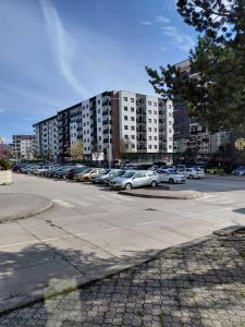 a parking lot with cars parked in front of a building at LOBO stan na dan in Lukavica