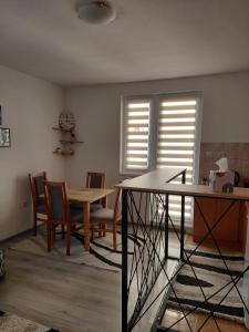 a dining room with a table and chairs and windows at LOBO stan na dan in Lukavica