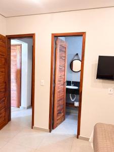 a bedroom with a door leading to a bathroom at Môzzi Barra Grande in Barra Grande