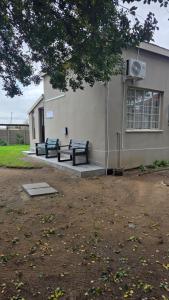 two benches sitting in front of a building at Morgenzon Lodge in Morgenzon