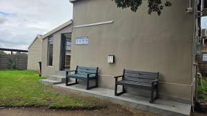 two benches sitting on the side of a building at Morgenzon Lodge in Morgenzon