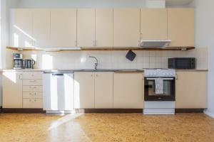 an empty kitchen with white cabinets and an oven at Functional and Spacious Apartment in Kopparberg in Kopparberg +12 photos