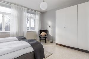 a bedroom with a bed and a chair and windows at Functional and Spacious Apartment in Kopparberg in Kopparberg
