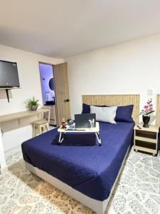 a bedroom with a bed with a laptop on it at Loft 4 Bambú in Laureles Stadium in Medellín