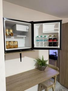 an open refrigerator filled with drinks and a wooden table at Loft 4 Bambú in Laureles Stadium in Medellín