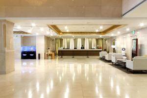 a lobby with white chairs and a hair salon at Daegu Grand Hotel in Daegu