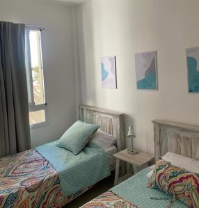 a bedroom with two beds and a window at Inehouse in Concepción del Uruguay
