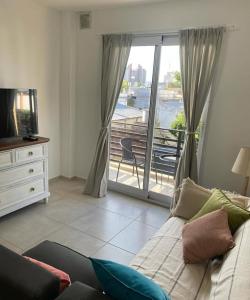 a living room with a couch and a view of a balcony at Inehouse in Concepción del Uruguay