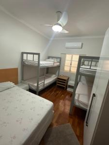 a room with two bunk beds and a ceiling fan at Hostel Muarama in Passos +44 photos