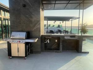 a outdoor kitchen with a grill and a table at Risco Centro de Bucerías beachfront with pool in Bucerías
