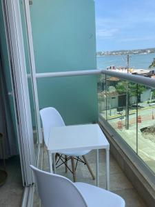 a white table and chairs on a balcony with a view of the ocean at Risco Centro de Bucerías beachfront with pool in Bucerías