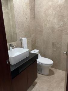 a bathroom with a sink and a toilet and a mirror at Risco Centro de Bucerías beachfront with pool in Bucerías +8 photos