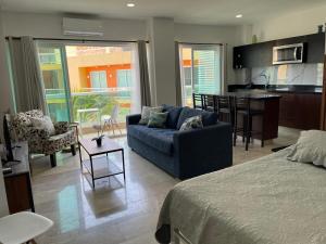 a living room with a blue couch and a kitchen at Risco Centro de Bucerías beachfront with pool in Bucerías