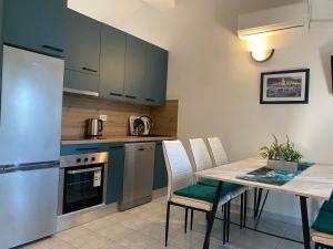a kitchen with blue cabinets and a table with chairs at Villa Ante Blace in Blace +45 photos