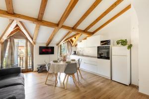 a kitchen and dining room with white cabinets and a table at Appartamento Vittoria in Cles