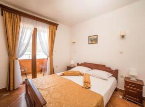 a bedroom with a bed with a cat sitting on it at Fiammanti Hotel Montenegro in Herceg-Novi