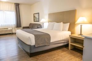 a hotel room with a large bed and a chair at The Tillamook Inn in Tillamook +33 photos