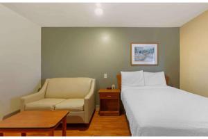 a hotel room with a bed and a chair at Studio 6 Extended Stay Birmingham Pelham AL in Pelham