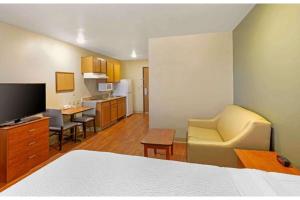 a hotel room with a bed and a living room at Studio 6 Extended Stay Birmingham Pelham AL in Pelham