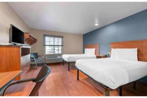 a hotel room with two beds and a television at Studio 6 Extended Stay Birmingham Pelham AL in Pelham