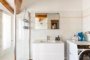 a white bathroom with a sink and a shower at Appartamento Vittoria in Cles +18 photos