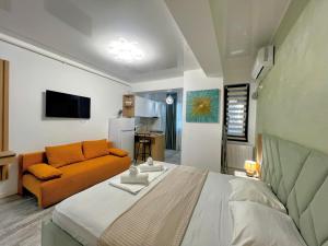 a bedroom with a large bed and a couch at Mamaia-NordCom Apartamente Exclusiviste S Resort 1 CBN la plaja Azimuth in Mamaia Sat/Năvodari