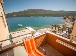 a balcony with a view of a beach and the ocean at Fiammanti Hotel Montenegro in Herceg-Novi