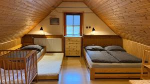 a attic bedroom with two beds and a window at Domeček Karlov in Malá Morávka