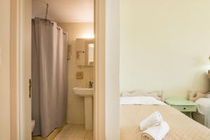 a bathroom with a bed and a sink and a shower at Maria Apartments in Amoopi +99 photos