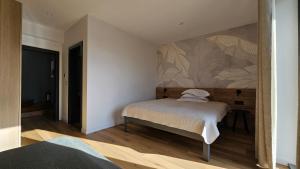 a bedroom with a bed and a painting on the wall at Bran Villa - A-frame Orchard Hygge in Bran