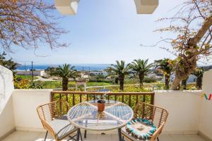 a patio with a glass table and chairs on a balcony at Maria Apartments in Amoopi