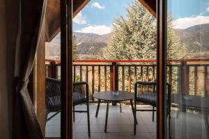 a balcony with two chairs and a table with a view at Appartamento Vittoria in Cles