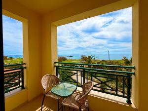 a balcony with a table and chairs and a view of the ocean at THERETRA KIOTARI VILLAS in Gennadi