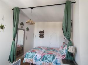 a bedroom with a bed with green curtains at Le Clos du Val in Chivres-Val