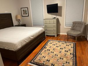 a bedroom with a bed and a chair and a television at Downtown house w on-site parking walk to museums, US Capital Scap in Washington, D.C.