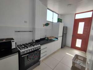 a kitchen with a stove top oven in a kitchen at Casa Chincha in San Pablo