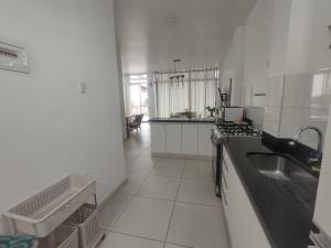 a white kitchen with a sink and a stove at Casa Chincha in San Pablo +12 photos