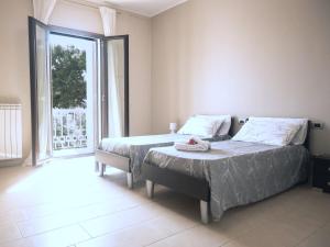 a bedroom with two beds and a large window at La Maison du Coeur in Bari
