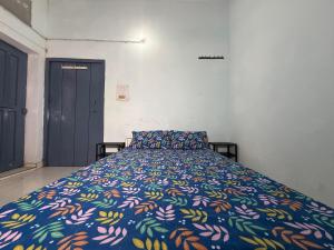 a bedroom with a bed with a colorful blanket at Nook Coliving Male Only in Lucknow +7 photos