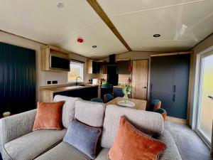 a living room with a couch and a kitchen at Barnharrow Holiday Park in Newton Stewart