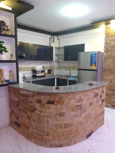a large kitchen with a brick counter in the middle at Appartement Saket Plage in Taranimt