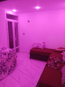 a room with two beds and a pink wall at Appartement Saket Plage in Taranimt