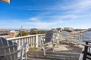 a row of chairs sitting on a deck with a view at 6151 - Once Upon a Tide in Nags Head