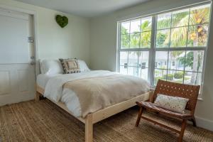 a bedroom with a bed and a chair and a window at Seahorse Beach Bungalows in Fort Pierce