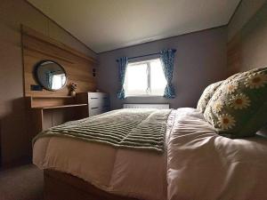 a bedroom with a bed and a window at Barnharrow Holiday Park in Newton Stewart