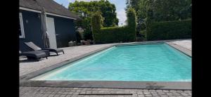 a swimming pool in front of a house at Villa France in Sevenum